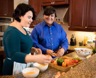 Two people preparing vegetables at a cutting board