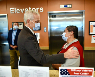 VA Secretary Denis McDonough greeting a volunteer at a VA clinic